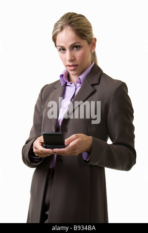 Attraktive blonde Frau gekleidet im grauen Business Anzug stehen auf weißem Hintergrund auf der Suche nach unten und tippen auf einen pager Stockfoto