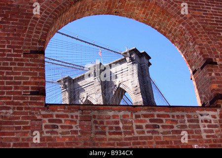 Die Brooklyn Bridge, gesehen durch ein Fenster des alten Tabak Warehouse in Fulton Landing State Park, New York City, USA Stockfoto