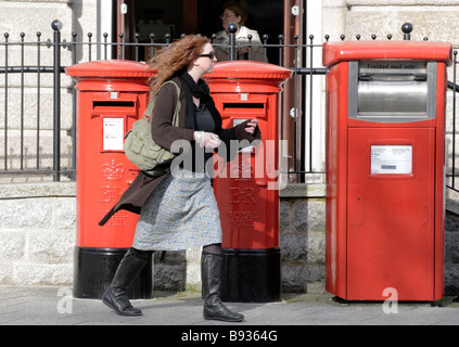 Eine Frau zu Fuß vorbei an Briefkästen in Falmouth, England Stockfoto