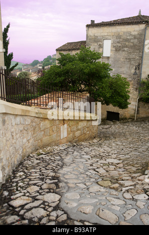 Eine gepflasterte Straße in St. Emilion Bordeaux Frankreich Kurven und Serpentinen unter grauem Himmel Stockfoto