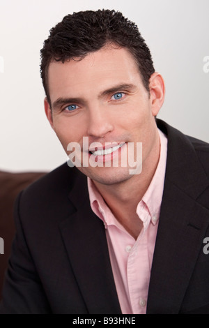 Ein hübscher junger Mann elegant gekleidet in einen Anzug und ein offenes necked rosa Hemd Stockfoto