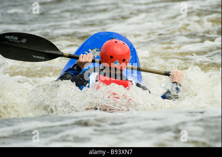 Rückansicht eines Kajakfahrers mit Kajak, der teilweise im weißen Wasser im Tees Barrage International White Water Center untergetaucht ist. VEREINIGTES KÖNIGREICH Stockfoto