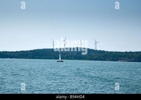 vier Windmühlen und ein Segelboot an einem sonnigen Tag Stockfoto