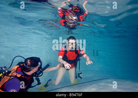 Junge Frau lernen Sie Tauchen im Pool mit Lehrer im Unterricht Tarierung unter Wasser