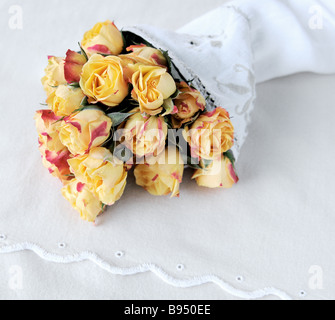 Miniatur-gelbe Rosen eingehüllt in ein Leinen-Serviette Stockfoto