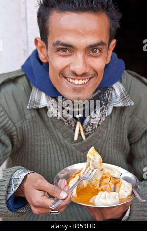 Nepali Kerl genießt Momo in Kathmandu Freak Street, Nepal Stockfoto