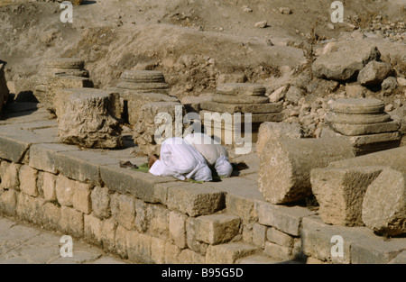 Jordanien Nahost Jerash zwei muslimische Männer kniend im archäologischen Ruinen in Richtung Mekka beten. Stockfoto