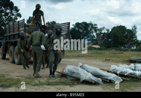 Vietnam-Krieg Central Highlands Belagerung von Kontum Montagnard Soldaten Gasmasken entladen Leichen in Plastik eingewickelt Stockfoto