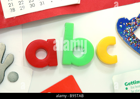 Farbige ABC Magnetbuchstaben auf einer weißen Kühlschranktür Stockfoto