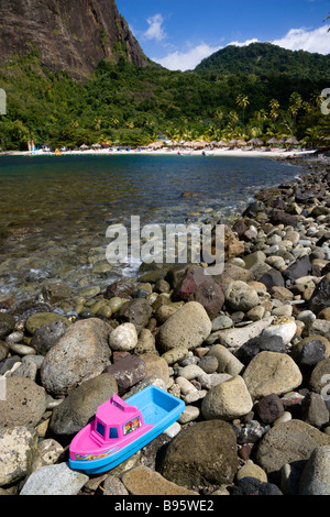 WEST INDIES Karibik St. Lucia Soufriere Kunststoff Spielzeugboot gestrandet auf Felsen auf dem Seeweg in Val des Pitons mit weißen Sandstrand Stockfoto