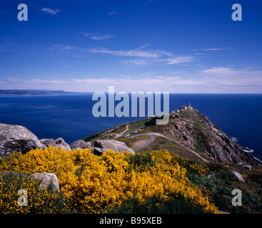 Spanien Galizien Cabo Fisterra Blick über felsige Halbinsel in Richtung Atlantik mit gelb blühenden Ginster im Vordergrund. Stockfoto