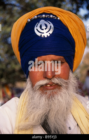 Indien in Südasien Delhi Porträt eines Sikh tragen orange und Königsblau Turban-Set mit einem Khanda, das Symbol des Sikhdom Stockfoto