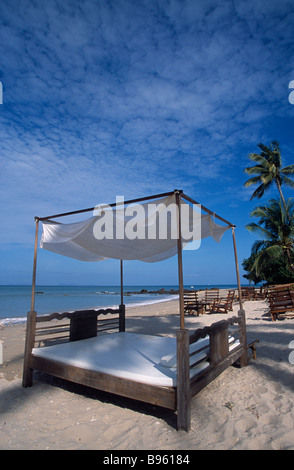 THAILAND Krabi Provinz Koh Lanta Yai Relax Bay Strand vier Himmelbett, Tisch und Stühlen auf Kokospalme leeren Strand gesäumt. Stockfoto