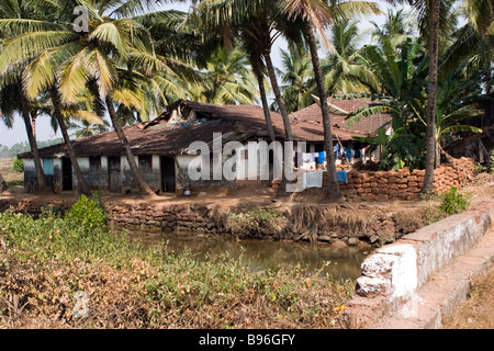 Typische äquatorialen asiatischen Residenz Haus am Ufer des Flusses mit Palmen umgeben. Stockfoto