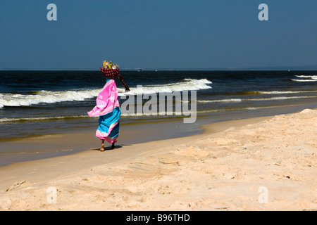 Küsten-Szene mit Frau, die Früchte trägt. Stockfoto