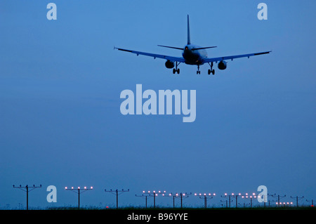 Düsenverkehrsflugzeug auf Ansatz über Start-und Landebahn Lichter am DFW International Airport unter bewölktem Himmel aber klarem Wetterbedingungen Stockfoto