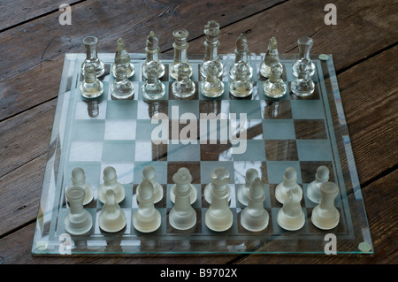 Glas-Schachspiel auf einem Holzfußboden Stockfoto