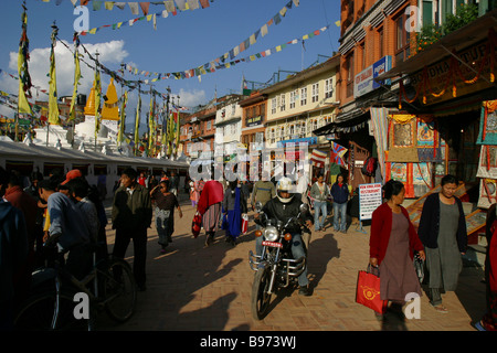 Ein Mann auf einem Motorrad und Menschen finden ihren Weg rund um Boudhanath Stupa in Kathmandu, Nepal. Stockfoto