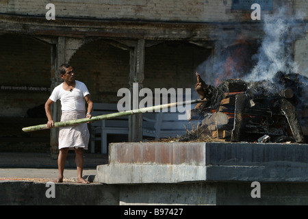 Ein Mann verbrennt eine Leiche auf einer Beerdigung Holz Pire im Pashupatinath Tempel in Kathmandu, Nepal. Stockfoto