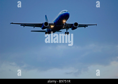 Düsenverkehrsflugzeug auf Ansatz über Start-und Landebahn Lichter am DFW International Airport unter bewölktem Himmel aber klarem Wetterbedingungen Stockfoto