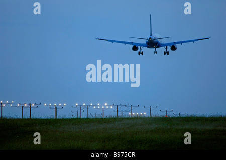 Düsenverkehrsflugzeug auf Ansatz über Start-und Landebahn Lichter am DFW International Airport unter bewölktem Himmel aber klarem Wetterbedingungen Stockfoto