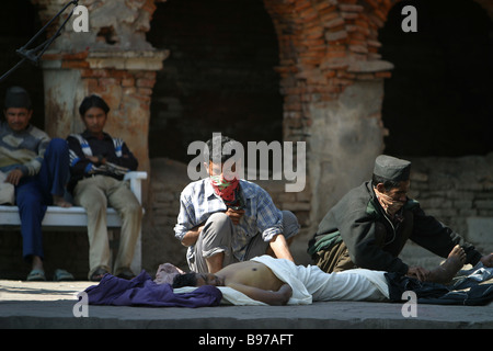 Männer bereiten eine Leiche für Feuerbestattung auf einer Beerdigung Holz Pire im Pashupatinath Tempel in Kathmandu, Nepal. Stockfoto