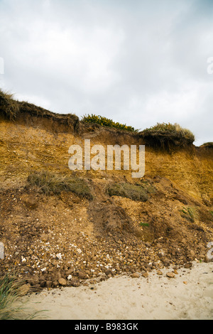 Küstenerosion.  Die Klippe am Oststrand von Bournemouth bröckelt entfernt, Freilegung der dunklen Oberseite-Bodenschichten. Dorset. VEREINIGTES KÖNIGREICH. Stockfoto