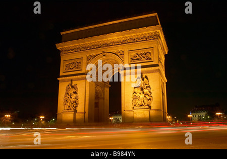 Verkehr schafft Lichtspuren auf dem Place Charles de Gaulle rund um den Arc de Triomphe an Nacht Paris, Frankreich. Stockfoto