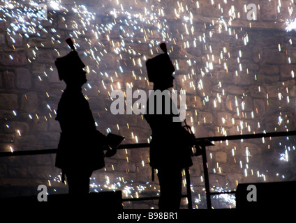 Silhouette von zwei Soldaten mit gefiederten Hüte und Trompete mit glitzernden Wasserfall von Feuerwerkskörpern im Hintergrund Stockfoto