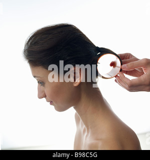 Junge Frau curling Haare mit Haar-Walze, Nahaufnahme Stockfoto