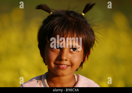 Nepalesische Mädchen in einem Senf Feld nahe dem Dorf von Sauraha, Nepal. Stockfoto