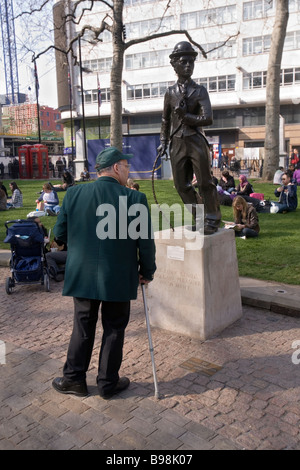 Mann sucht ein Charlie Chaplin-Statue in Leicester Square in London Stockfoto