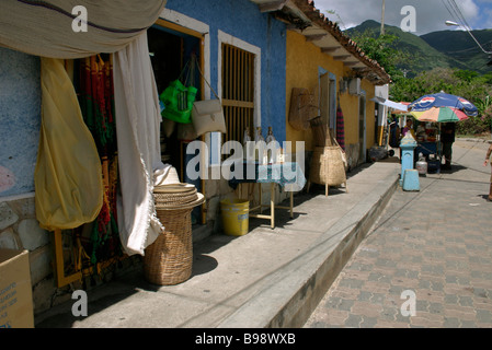 Straße in der Stadt. Reihen von Reihenhäusern.  Geschäfte. Türöffnungen. Ware auf dem Display. EL VALLE. ISLA MARGARITA. Venezuela. Stockfoto