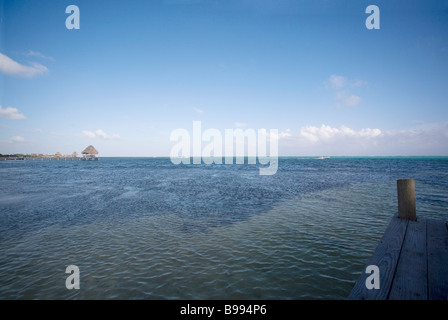 Sonnenuntergang am späten Nachmittag beim Sitzen auf einem Dock in ruhigem Wasser auf Ambergris Caye, Belize nähert. Stockfoto