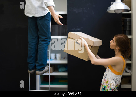 Frau Übergabe Feld Mann auf Leiter Stockfoto