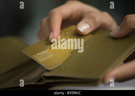 Frau Hand nehmen Kreditkarte aus Brieftasche Stockfoto