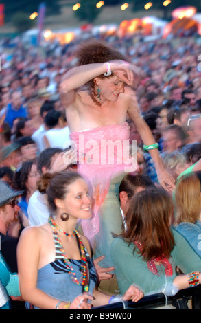 Mädchen tanzen auf den Schultern ihrer Freundin in der Menge auf einem Festival Stockfoto