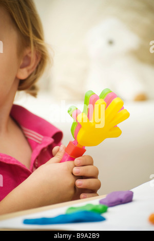 Kleines Mädchen hält klatschenden Plastikspielzeug, beschnitten Ansicht Stockfoto