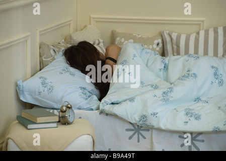 Junge Frau im Bett, Rückansicht Stockfoto