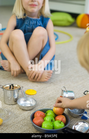 Kinder sitzen am Boden, spielen mit Töpfen und Pfannen, beschnitten Stockfoto