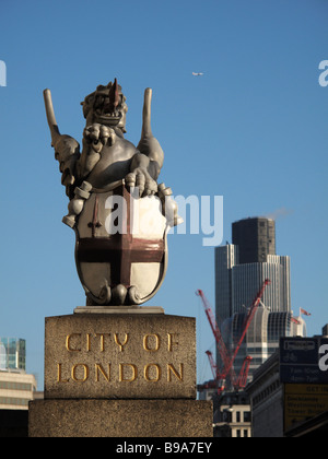 Drachen und Schild mit St.-Georgs-Kreuz auf der Londoner Brücke am Eingang der Stadt von London Nat West Tower im Hintergrund Stockfoto