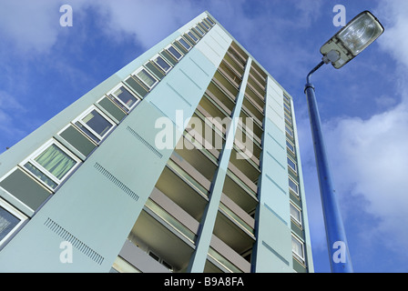 Eine renovierte 60er Block der Wohnungen bis hin zu dem Lückenhaften bewölkte Himmel mit einem Lamp Post in einer Ecke gesehen Stockfoto