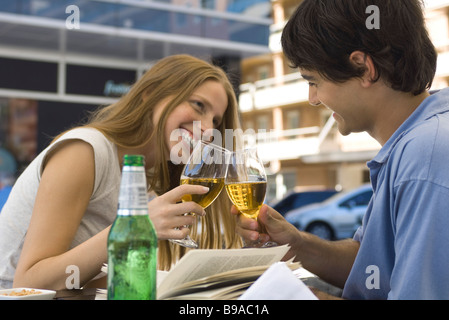 Junges Paar klirrende Gläser Bier im Café im freien Stockfoto