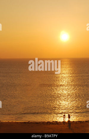 Ein Sonnenuntergang am Strand von Godrevy mit ein paar Leuten zwischen den Strahlen des Lichtes Stockfoto