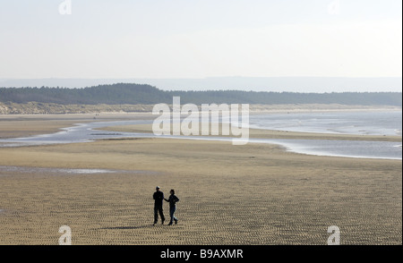 Paare, die am sandigen Strand von Burghead auf der Moray Küste von Schottland, UK Stockfoto