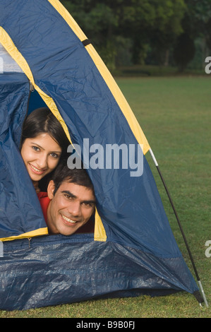 Paar spähen aus einem Zelt-Eröffnung Stockfoto