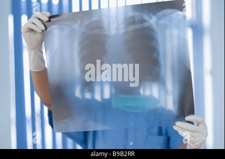 Weibliche Chirurg untersuchen einen Röntgen-Bericht Stockfoto