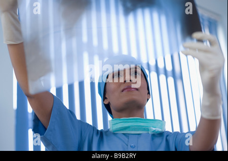 Weibliche Chirurg untersuchen einen Röntgen-Bericht Stockfoto