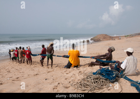 Net-West Afrika Ghana Cape Coast Village Fischer in einer Reihe stehen und zieht aus dem Meer Stockfoto