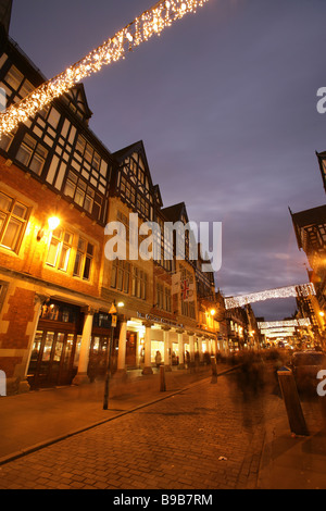 Von Chester, England. Nachtansicht einer anstrengenden shopping Weihnachten Szene Chesters Eastgate Street. Stockfoto